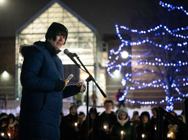 Jenny Hall-Jones stands on a small stage beneath the clock tower, addressing the crowd.