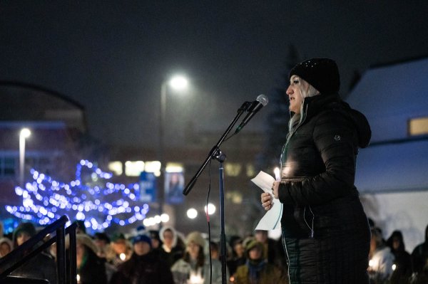Faith Kidd stands on a small stage beneath the clock tower, addressing the crowd.