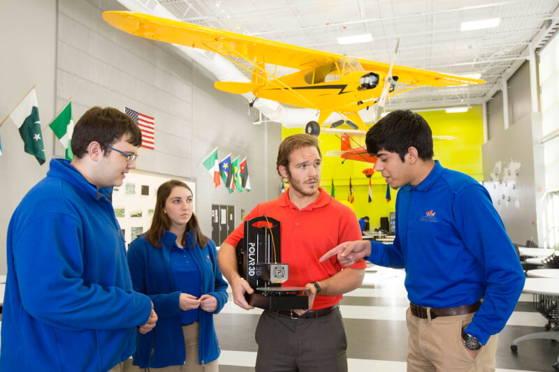 students and grad assistant in airplane hanger