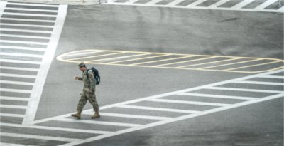 A military member crosses the street.