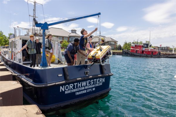 Students at Northwestern Michigan College prepare to lower a remotely operated vehicle into Grand Traverse Bay. 
