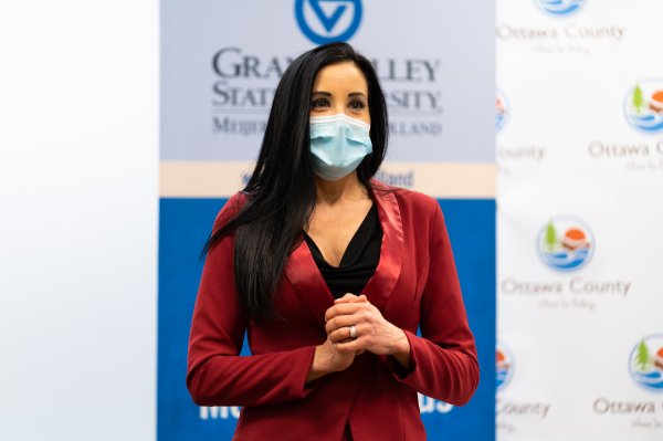 woman wearing red sweater speaking in front of audience