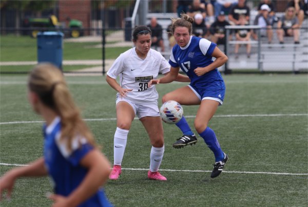 A GVSU women's soccer player fights for possession of a ball while a Purdue Northwest women's soccer player looks to intercept.