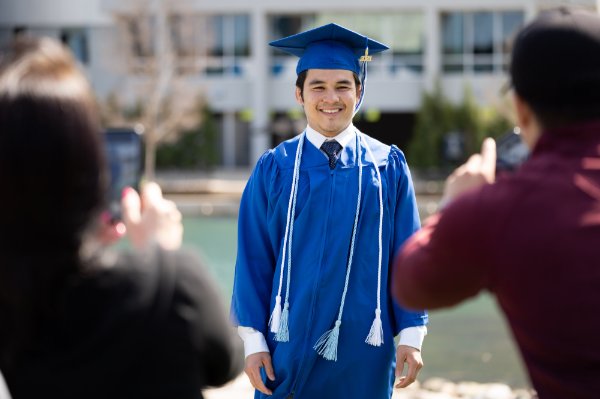 Supporters take a photo of a graduate.
