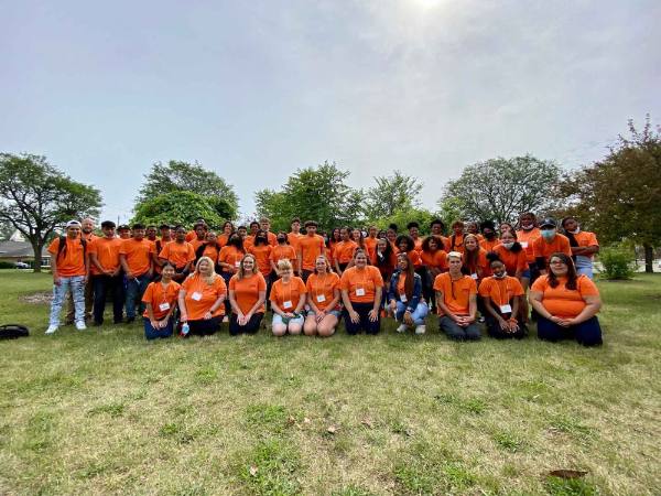Group of high school students in orange shirts and staff members at the ExCEL Camp.