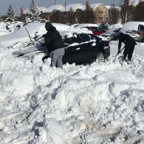Members of GVPD help students on the Allendale Campus remove snow from their cars.