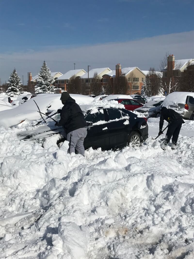 Members of GVPD help students on the Allendale Campus remove snow from their cars.