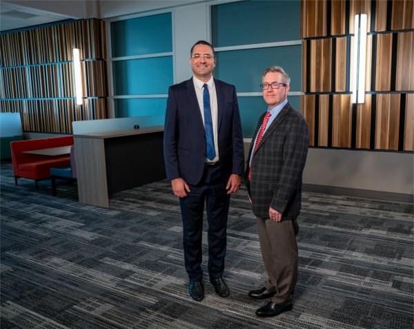 Two people stand in a GVSU academic building for a photo.