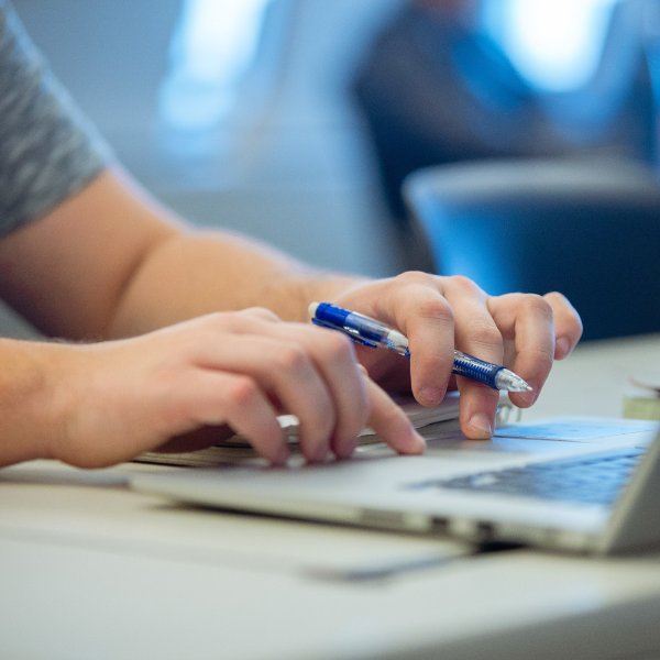 A person uses the trackpad on a laptop computer.