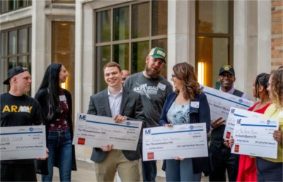 Spencer Scarber holds his winning check with other participants following pitch competition presented by Michigan Veterans Enterpreneur-Lab