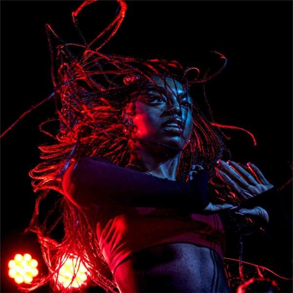 Red stage lights highlight a student dancing during Laker Kickoff.
