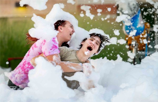  Two college students frolic in a foam pit. 