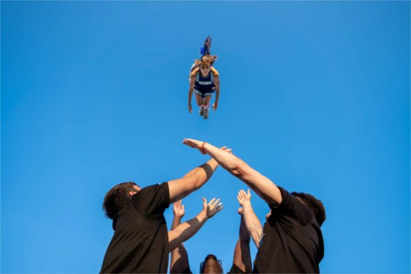  A cheerleader flies through the air during a stunt. 