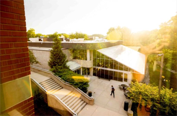  A student walks through a college campus during sunrise. 