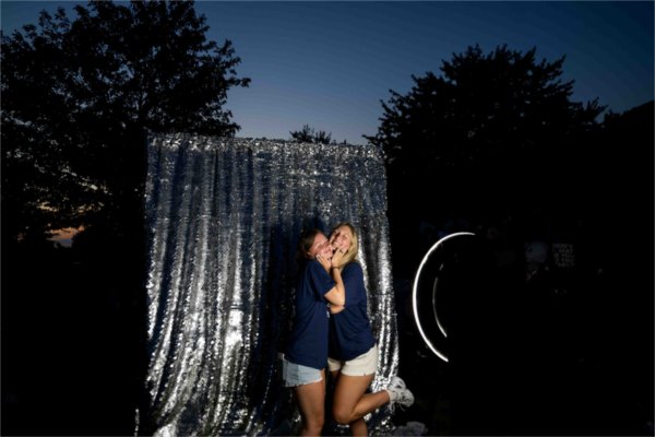  Two college students pose for a photo with their faces smooshed together. 