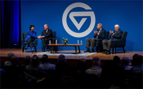 Four university presidents sit on a stage during a panel discussion. 