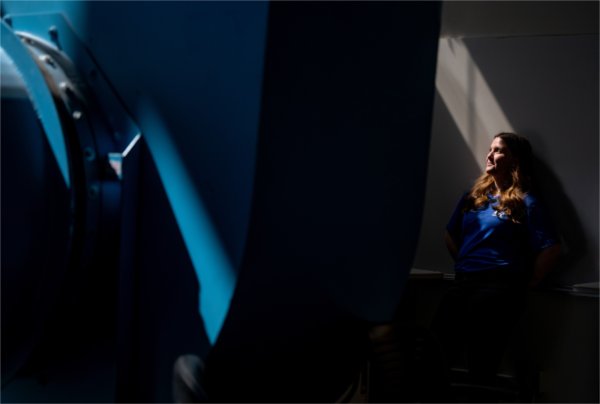 During a portrait of a college student a beam of light hits their face and a blue wind tunnel. 