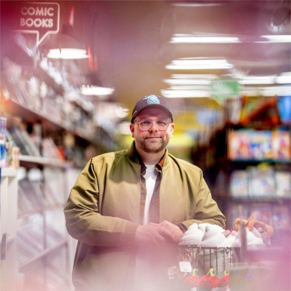 Alumnus Kenny Porter is a comic book writer. Porter was a writing major at Grand Valley. He poses in Vault of Midnight, a local downtown Grand Rapids comic book shop, where his books are sold.