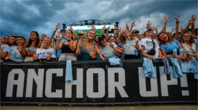 GVSU students hold up the "Anchor Up" hand sign during a football game. 
