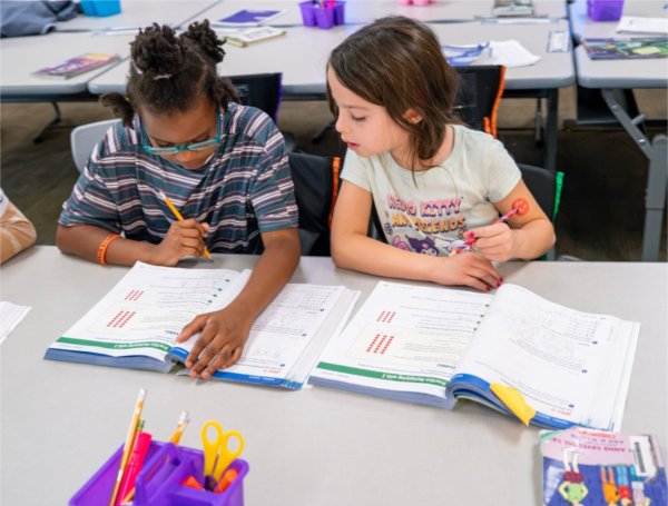 Jada&#8217;Dee House, left, and Josephine Bautista work together at their desks at Challenger Elementary in Kentwood.