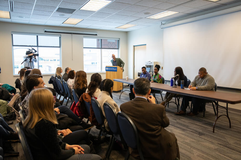 man at podium leading a panel
