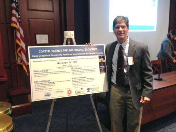 Al Steinman stands by research poster about Great Lakes restoration.