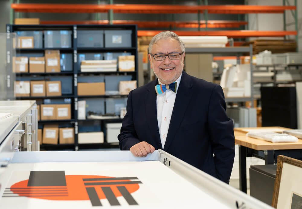 Henry Matthews, who has a new position in University Development, stands by the print and drawing cabinet in the art storage room, located in the Innovation Design Center. There are 9,000 pieces of artwork stored in the building on Winter Street.