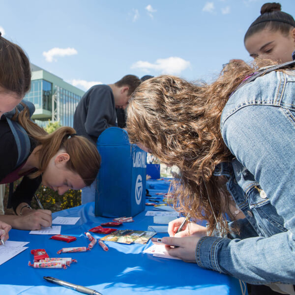 Three female students writing postcards