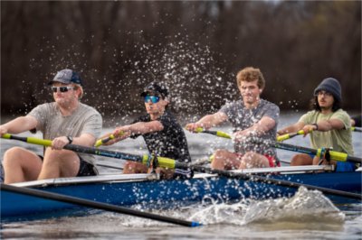 four rowers in a shell, water droplets coming off the oars