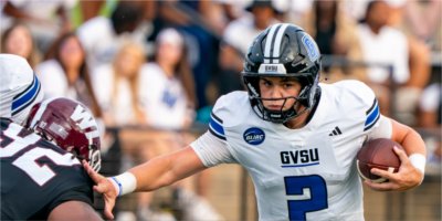 Grand Valley quarterback Andrew Schuster tries to shake off a tackle by a West Texas A&M player.