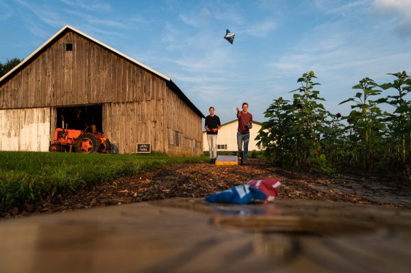 The Bremer brothers play cornhole on their family farm