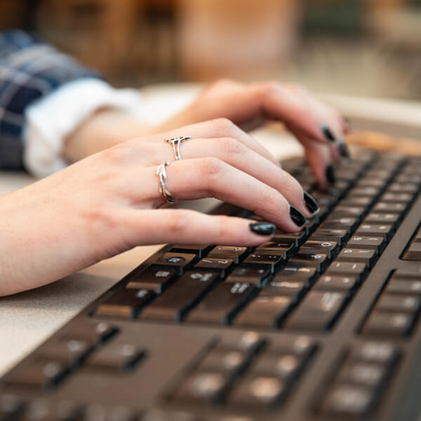 A student types on a computer keyboard.