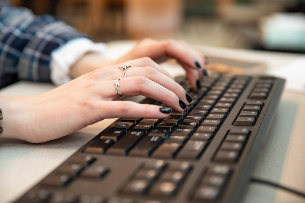 A student types on a computer keyboard.