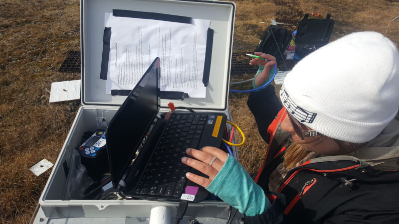 Graduate student Katlyn Betway downloading sensor observations in Utqiagvik, Alaska.