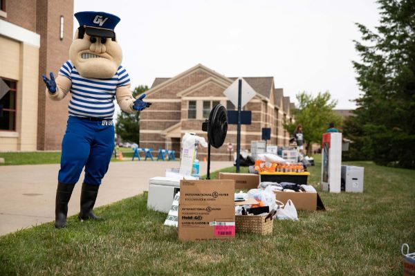 Louie the Laker stands next to boxes at move-in.