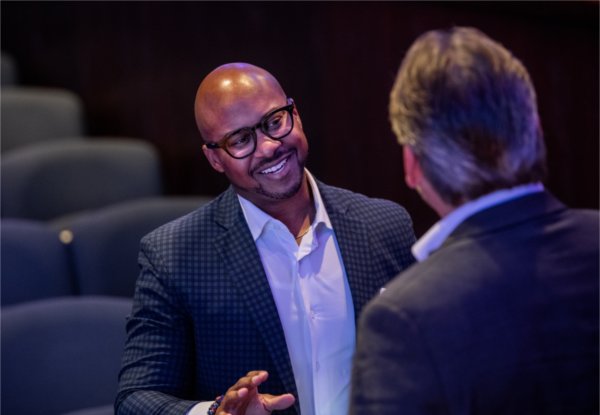 Rodney Robinson, with Dell Technologies, left, talks with a guest after speaking during "Tech Talks: AI & Human-Centered Design" at the DeVos Center's Loosemore Auditorium in Grand Rapids on September 18.