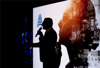 College of Computing Dean Marouane Kessentini is silhouetted against a backdrop at a Tech Talk