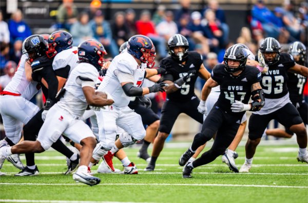 Football players look to make a tackle on the field during a college football game. 