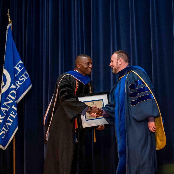 Felix Ngassa, professor of chemistry and chair of the University Academic Senate, presents Matthew Hart, associate professor of chemistry, right, the University Outstanding Teacher Award during the Faculty Awards Convocation.