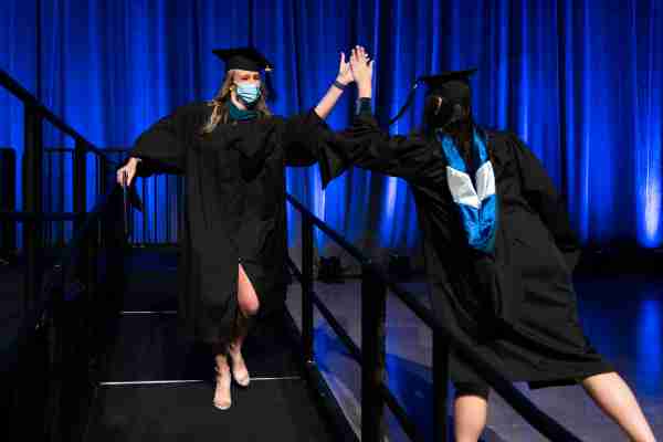 Two graduates high five.