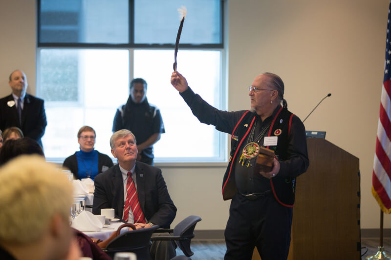 Steven Naganashe Perry, of Grand Valley's Native American Advisory Council, presented President Haas with a feather.