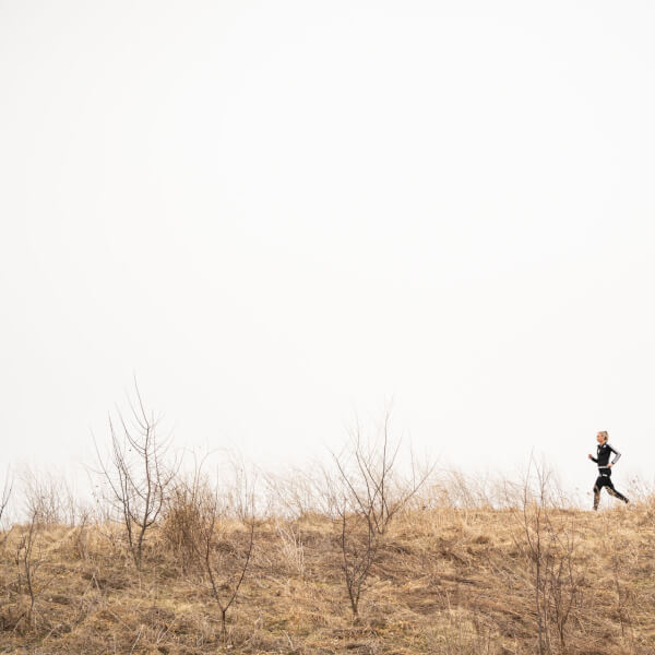 Photo of a student running near a field.