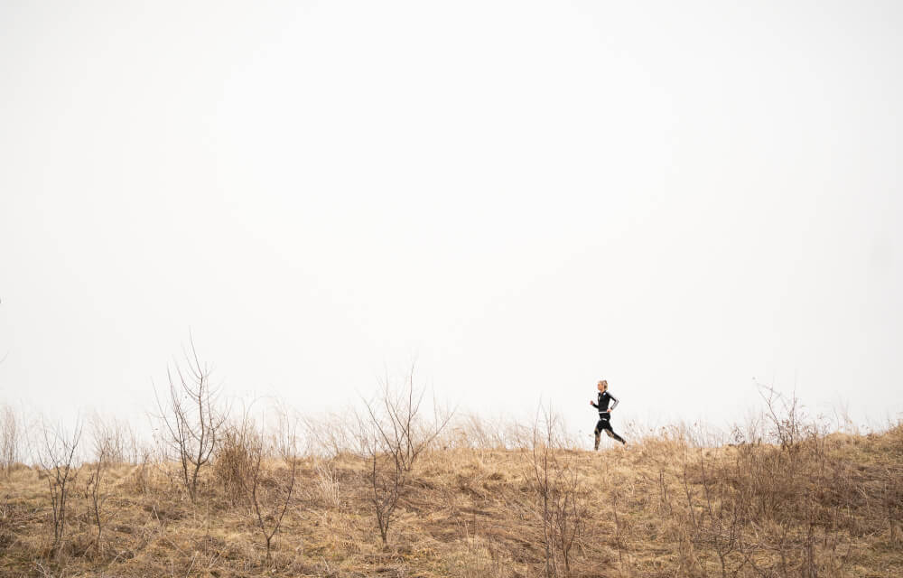 Photo of a student running near a field.