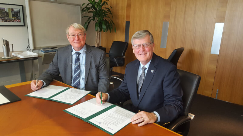 President Haas, right, and Greg Hill, vice chancellor of the University of Sunshine Coast (USC) in Australia, signed a new five-year agreement to extend the partnership between the two universities.