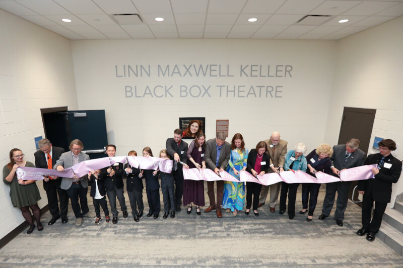 The Keller family, along with members of the Grand Valley community, cutting the dedication ribbon for the Keller Theatre
