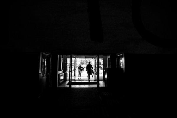  Silhouette of two people carrying belongings into a living center. 