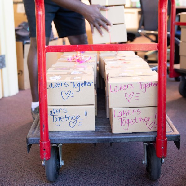 Care packages are loaded on a cart, Lakers Together drawn on packages