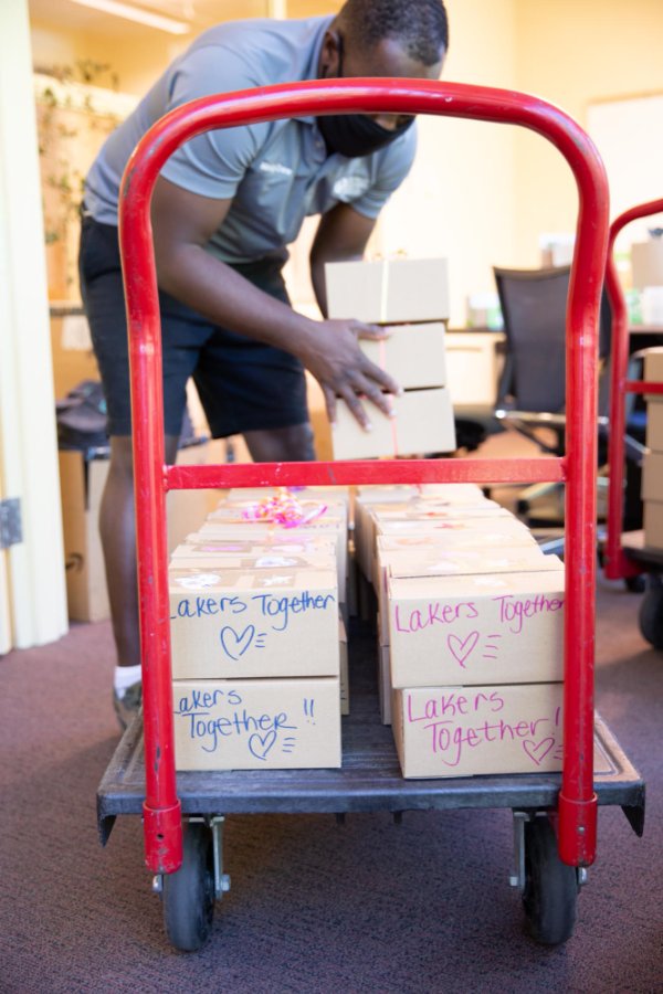 Care packages are loaded on a cart, with handwritten notes on the outside and bows