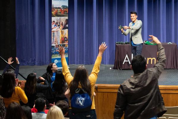 Michael Guerra, admissions counselor, speaks to an audience from a stage at the 2019 ALSAME conference.