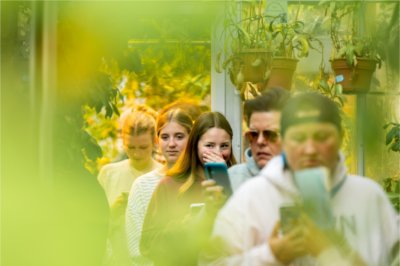 Five people wait in line for the corpse flower. One person holds their nose.